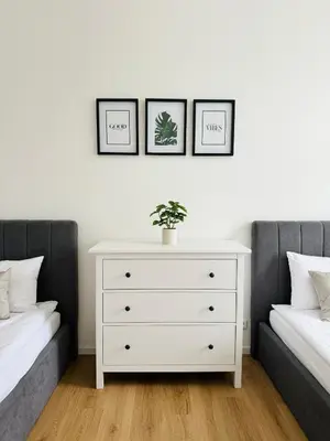 a bedroom with two beds and a white dresser at Apartman Namesti Miru in Prague