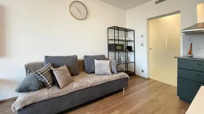 a living room with a couch and a clock on the wall at Matilda108 in Prague