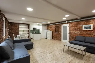 a living room with two couches and a brick wall at Spacious apartment in quiet courtyard near Charles Bridge in Prague