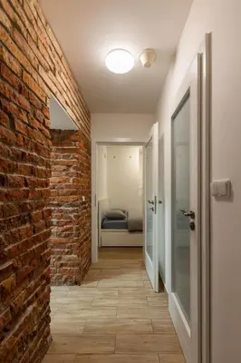 a hallway with a brick wall and a door at Spacious apartment in quiet courtyard near Charles Bridge in Prague