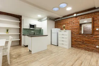 a kitchen with a brick wall and a white refrigerator at Spacious apartment in quiet courtyard near Charles Bridge in Prague