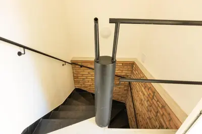 a stairwell with a metal pole in a room at Spacious apartment in quiet courtyard near Charles Bridge in Prague
