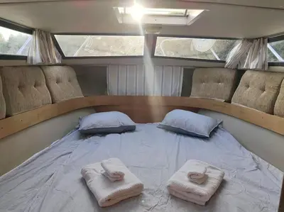 a bed in a boat with two pillows on it at Wake Port Boat, ubytování na lodi in Brandýs nad Labem-Stará Boleslav