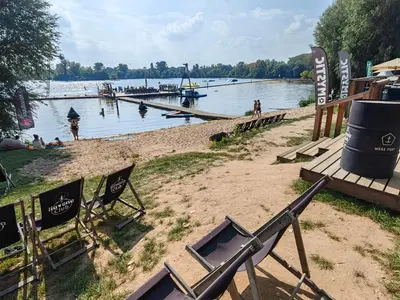 a group of chairs sitting on the shore of a lake at Wake Port Boat, ubytování na lodi in Brandýs nad Labem-Stará Boleslav