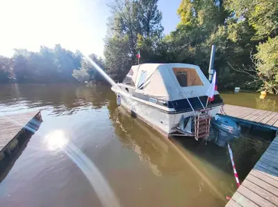 a boat tied up to a dock in the water at Wake Port Boat, ubytování na lodi in Brandýs nad Labem-Stará Boleslav