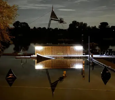 a boat is docked in the water at night at Wake Port Boat, ubytování na lodi in Brandýs nad Labem-Stará Boleslav