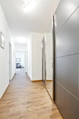 a hallway with white walls and a metal elevator at Melody in Prague