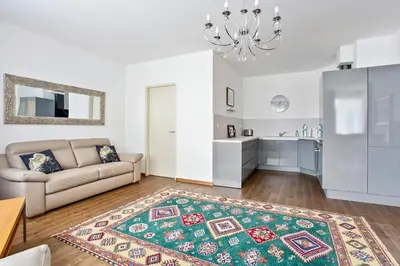 a living room with a couch and a kitchen at Melody in Prague