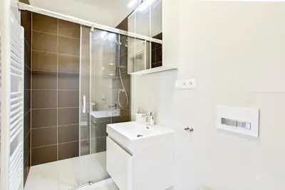 a white bathroom with a sink and a shower at Melody in Prague