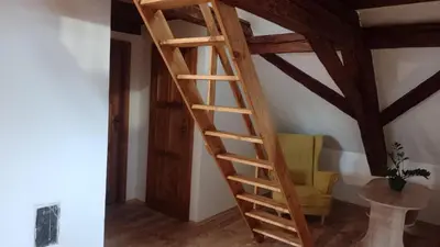 a wooden staircase in a room with a yellow chair at Ubytování Ždírec - Apartmán 1 in Ždírec