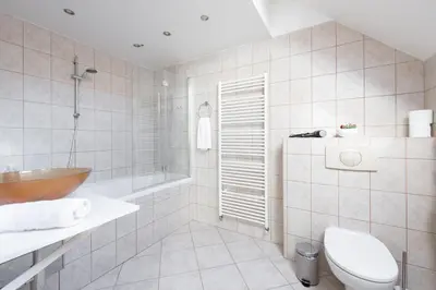 a bathroom with a tub and a toilet and a sink at Spacious apartments near National theatre in Prague