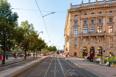 an empty street in front of a large building at Spacious apartments near National theatre in Prague
