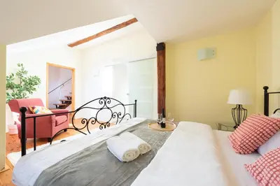 a bedroom with a bed and a living room at Spacious apartments near National theatre in Prague