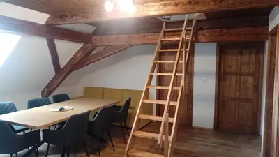 a wooden ladder in a room with a table and chairs at Ubytování Ždírec in Ždírec