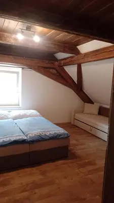 a bedroom with a bed and a window and wooden ceilings at Ubytování Ždírec in Ždírec