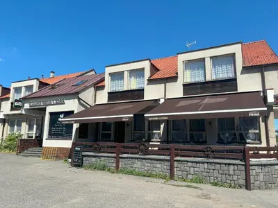 a building with a restaurant with a fence in front of it at Restaurace a penzion U Jezírka in Hřiměždice