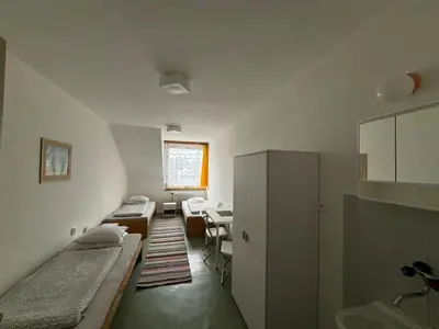 a room with two beds and a desk in it at Restaurace a penzion U Jezírka in Hřiměždice