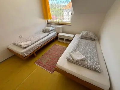 two beds in a small room with a window at Restaurace a penzion U Jezírka in Hřiměždice