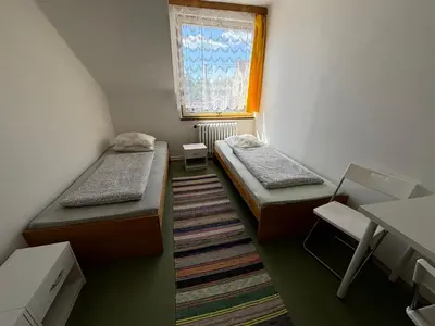 a small room with two beds and a window at Restaurace a penzion U Jezírka in Hřiměždice