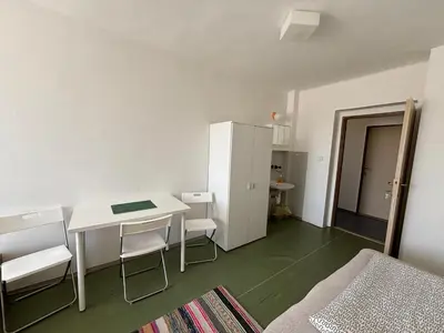 a small room with a table and chairs and a bed at Restaurace a penzion U Jezírka in Hřiměždice