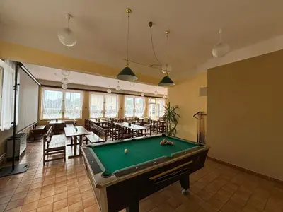 a pool table in a room with tables and chairs at Restaurace a penzion U Jezírka in Hřiměždice