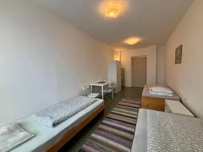a small room with two beds and a desk at Restaurace a penzion U Jezírka in Hřiměždice