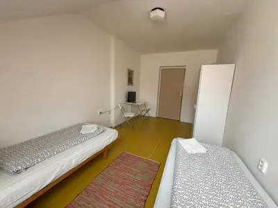 a room with two beds and a desk in it at Restaurace a penzion U Jezírka in Hřiměždice