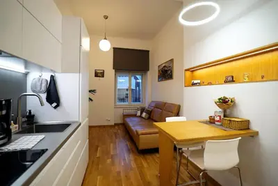 a kitchen and living room with a table and a couch at Cozy apartment with garage in Prague