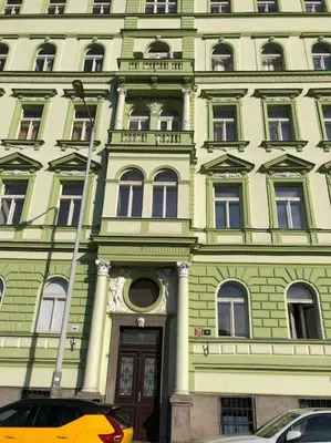 a green building with a door in front of it at Cozy apartment with garage in Prague