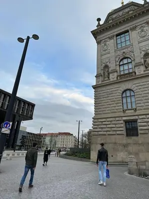 two men walking in front of a building at Cozy apartment with garage in Prague