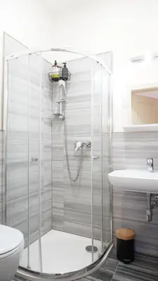 a bathroom with a shower and a toilet and a sink at Flat with Balcony and Garage in Prague