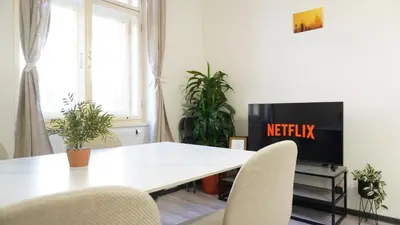 a living room with a table and chairs and a tv at Flat with Balcony and Garage in Prague