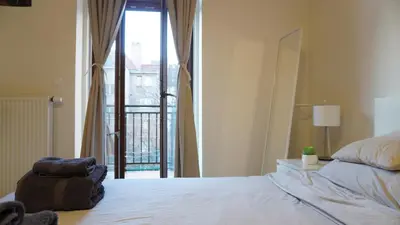 a bedroom with a bed with a view of a balcony at Flat with Balcony and Garage in Prague