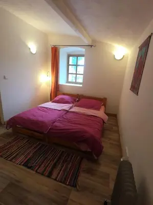 a bedroom with a bed with purple sheets and a window at Lavender Apartment - perfect for families! in Stranný