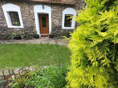 a stone house with a wooden door and a yard at Lavender Apartment - perfect for families! in Stranný