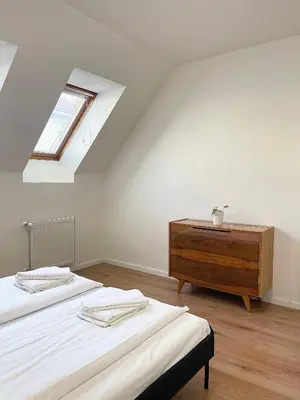 a attic bedroom with two beds and a dresser at Cozy Atmos Apartments in Prague