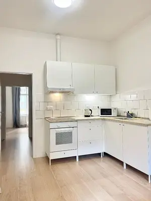 a kitchen with white cabinets and white appliances at Cozy Atmos Apartments in Prague