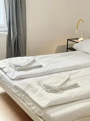 two beds with white sheets and towels on them at Cozy Atmos Apartments in Prague