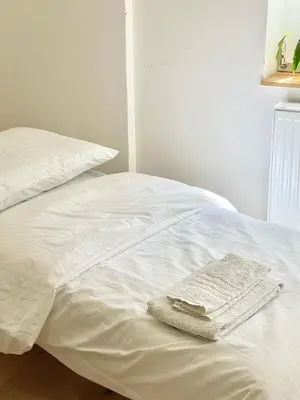 a white bed with two towels on top of it at Cozy Atmos Apartments in Prague