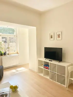 a living room with a flat screen tv on a white cabinet at Cozy Atmos Apartments in Prague