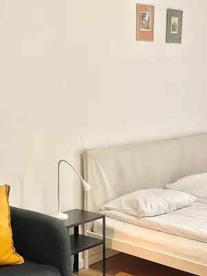 a bedroom with a bed and a table with a lamp at Cozy Atmos Apartments in Prague