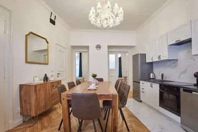 a kitchen and dining room with a wooden table and chairs at National Theatre Elegance Residence in Prague