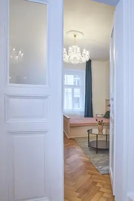 a hallway with a room with a bed and a chandelier at National Theatre Elegance Residence in Prague