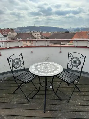 two chairs and a table on a balcony at Luxury apartment with terrace and garage in Prague