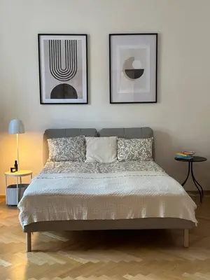 a bedroom with a bed with two pictures on the wall at Spacious Elegance - A Central Gem in Prague