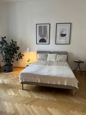 a bedroom with a bed and two pictures on the wall at Spacious Elegance - A Central Gem in Prague