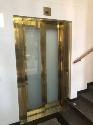 a elevator in a building with glass doors and stairs at Spacious Elegance - A Central Gem in Prague