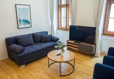 a living room with a blue couch and a table at City Centre Apartment with Parking in Prague