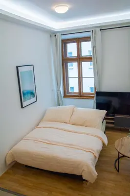 a bed in a white room with a window at City Centre Apartment with Parking in Prague