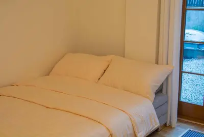 a bed with white sheets in a room with a window at New City Centre Garden Apartment - Central Location in Prague